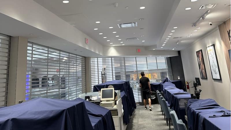 Display counters in a retail store under navy protective covers, with the ceiling registers above them